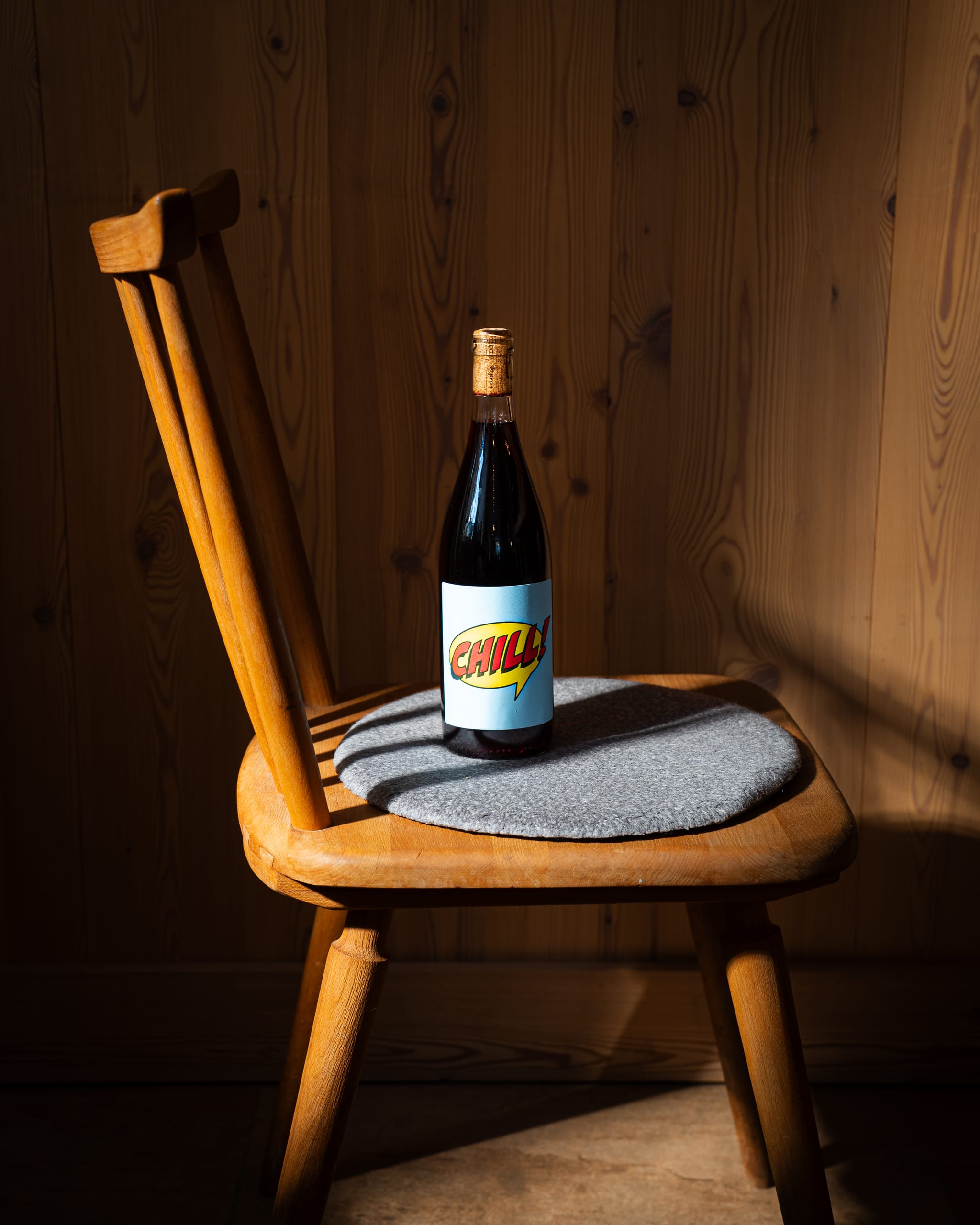 Wine bottle with a bright label on a wooden chair