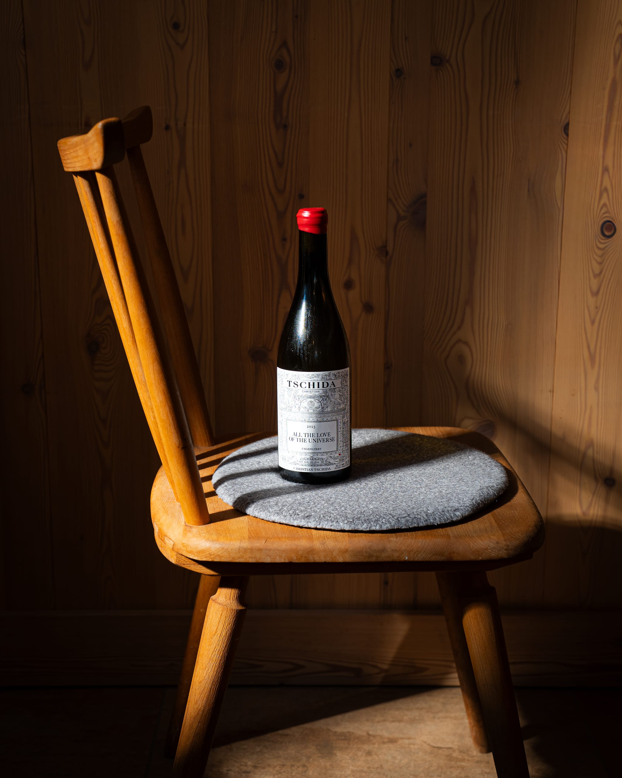 Red-capped wine bottle on a wooden chair