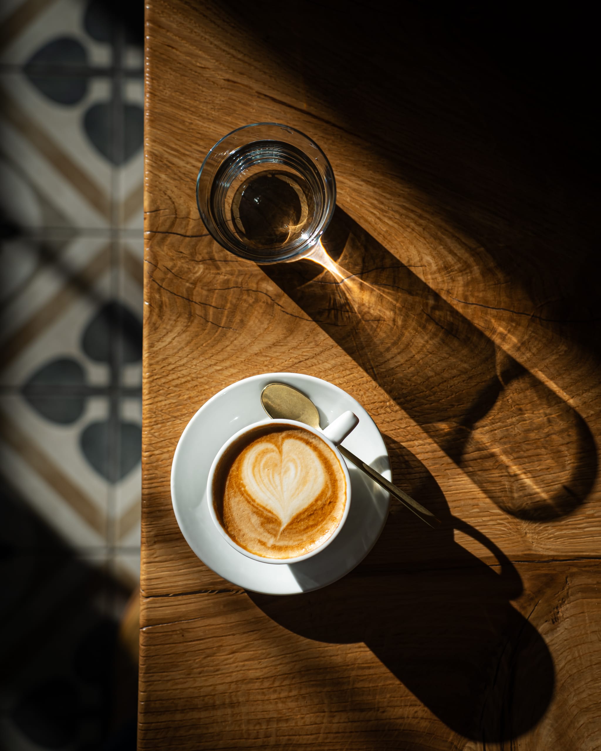 Latte on a wooden table in hard morning light