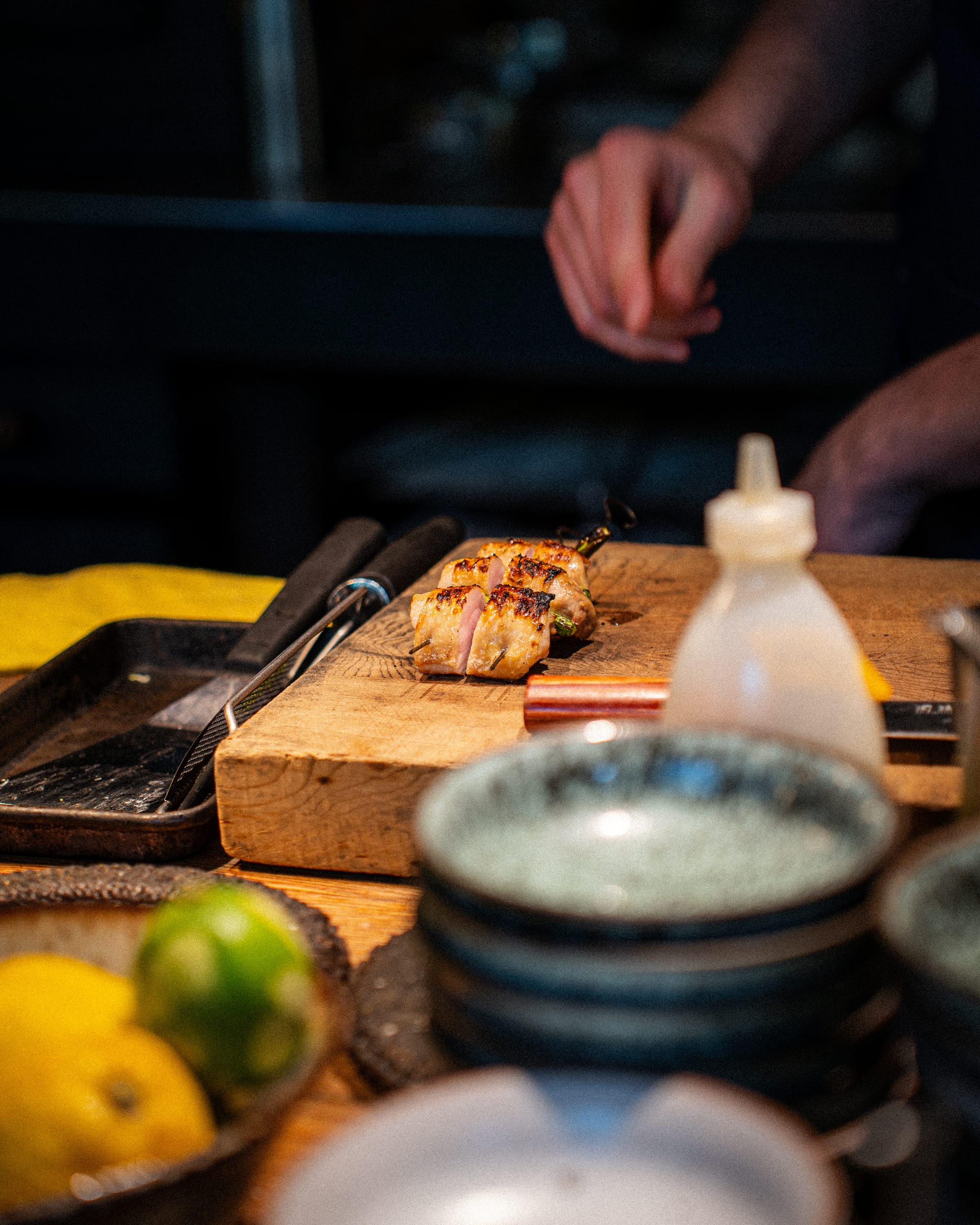 Knife work on a board beside lemons