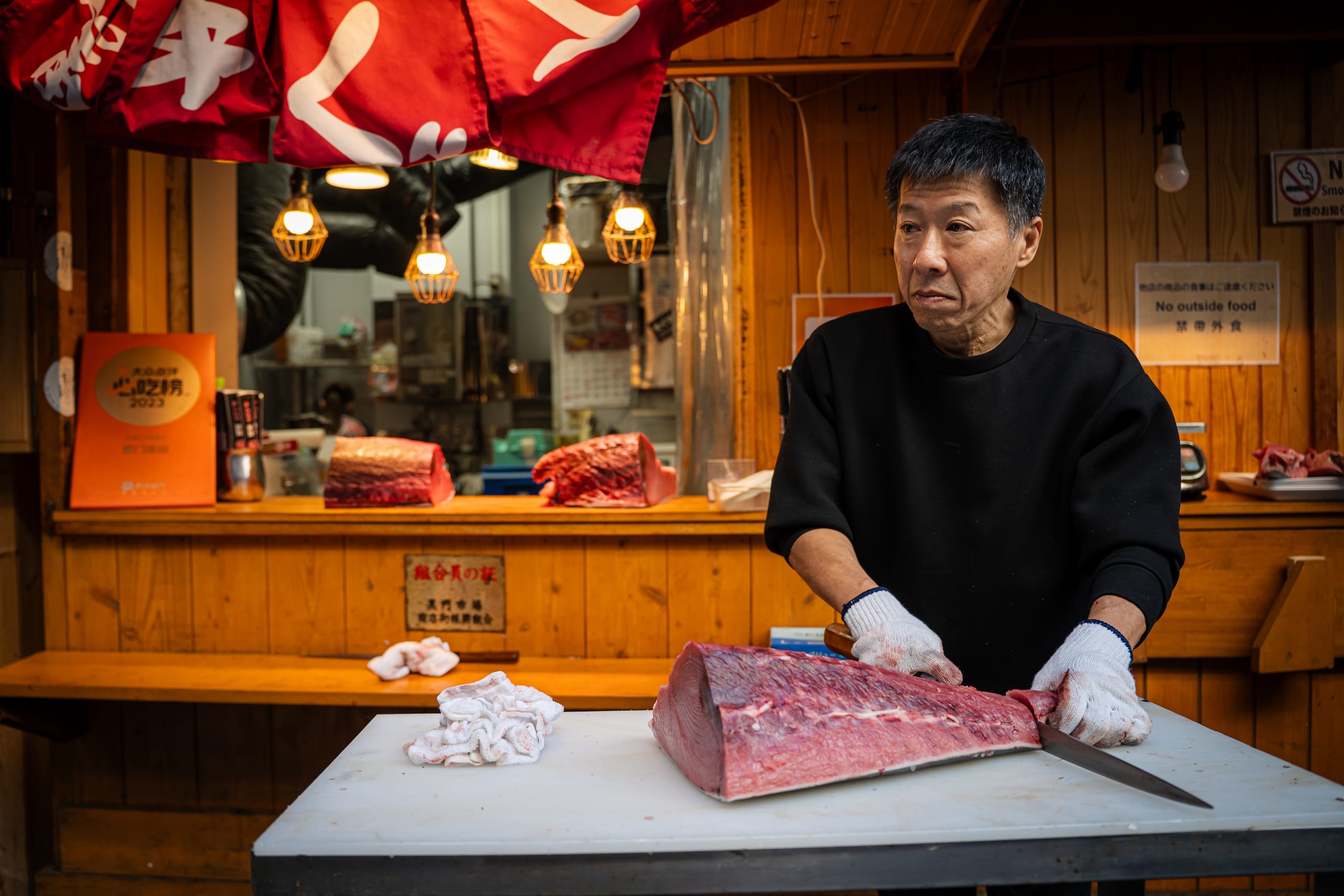 Fishmonger slicing a block of tuna