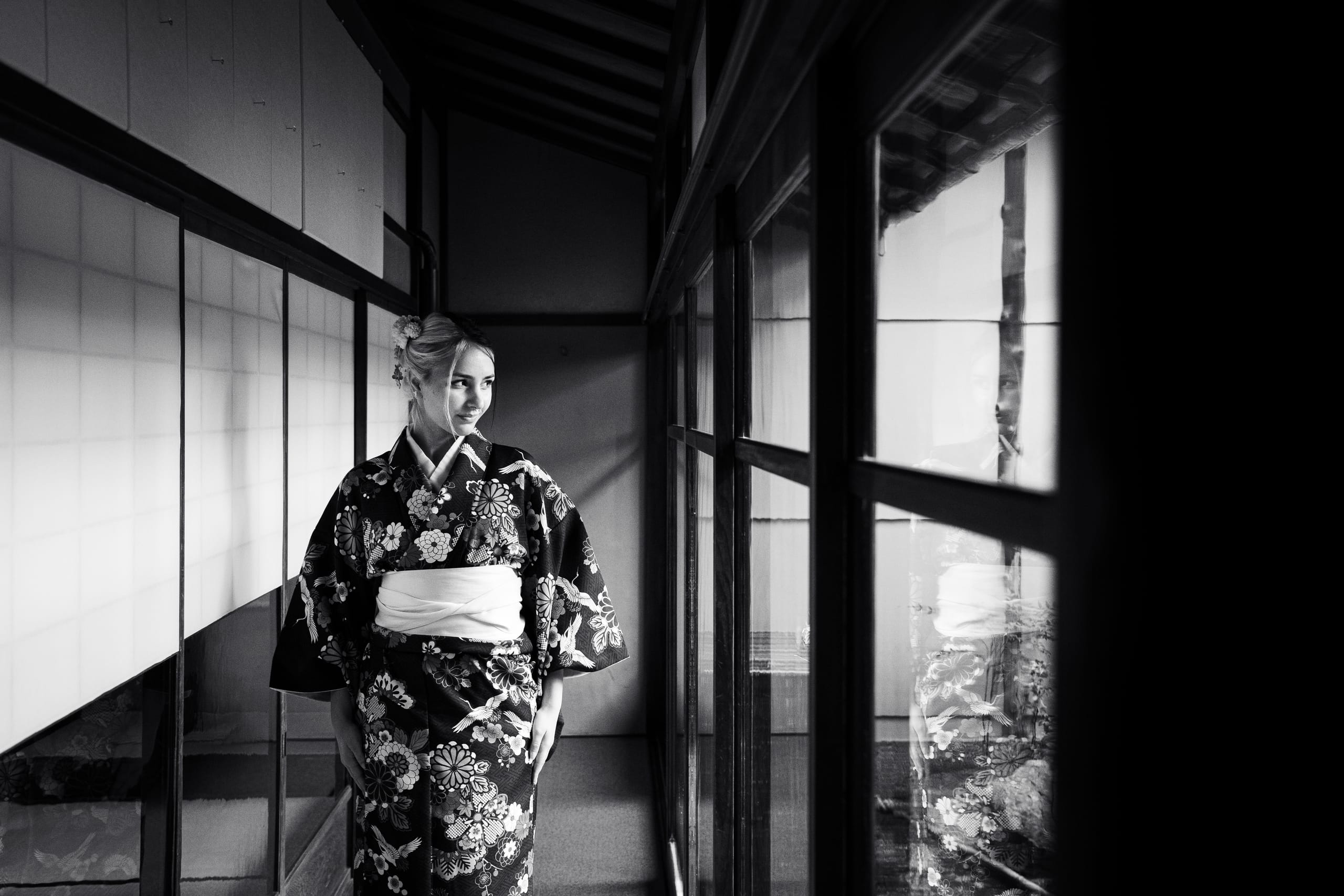 Woman in kimono by a window, black and white