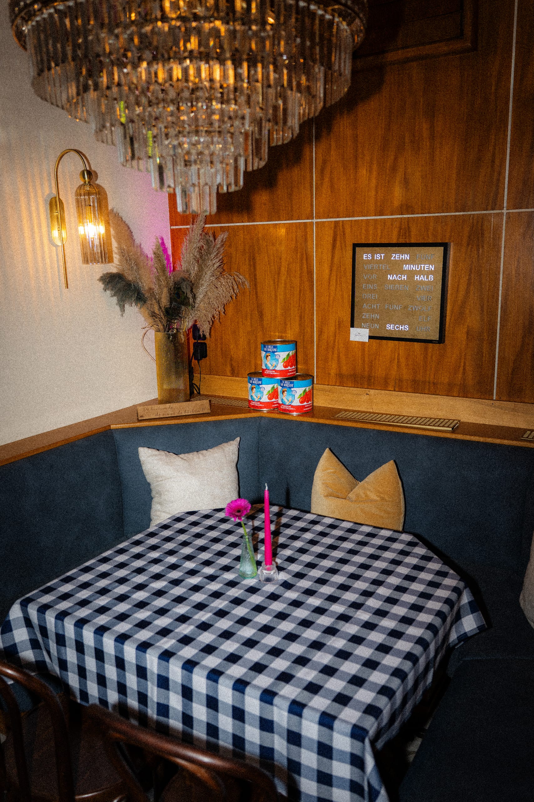 Corner booth with a chequered tablecloth under a chandelier
