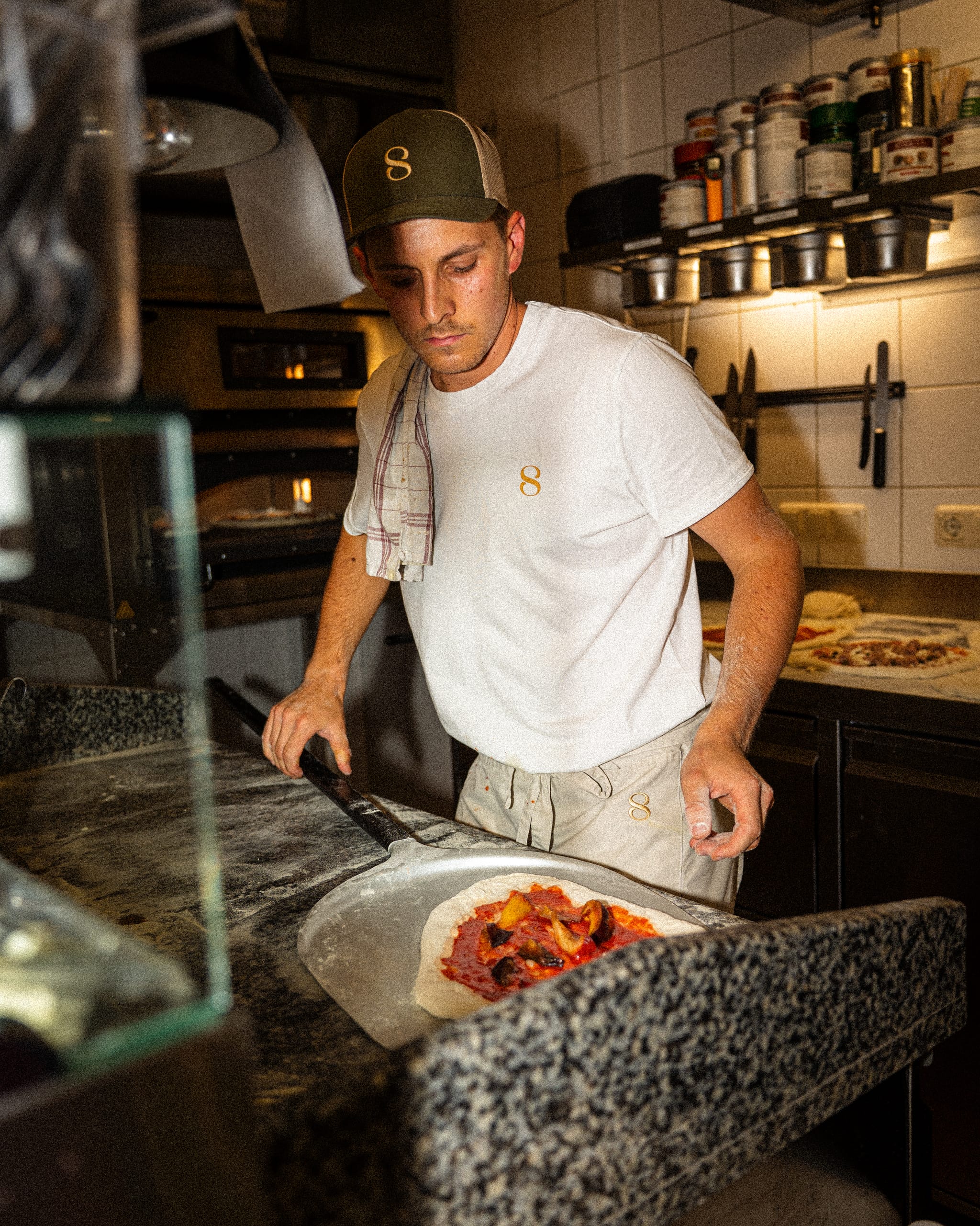 Pizzaiolo working at the oven