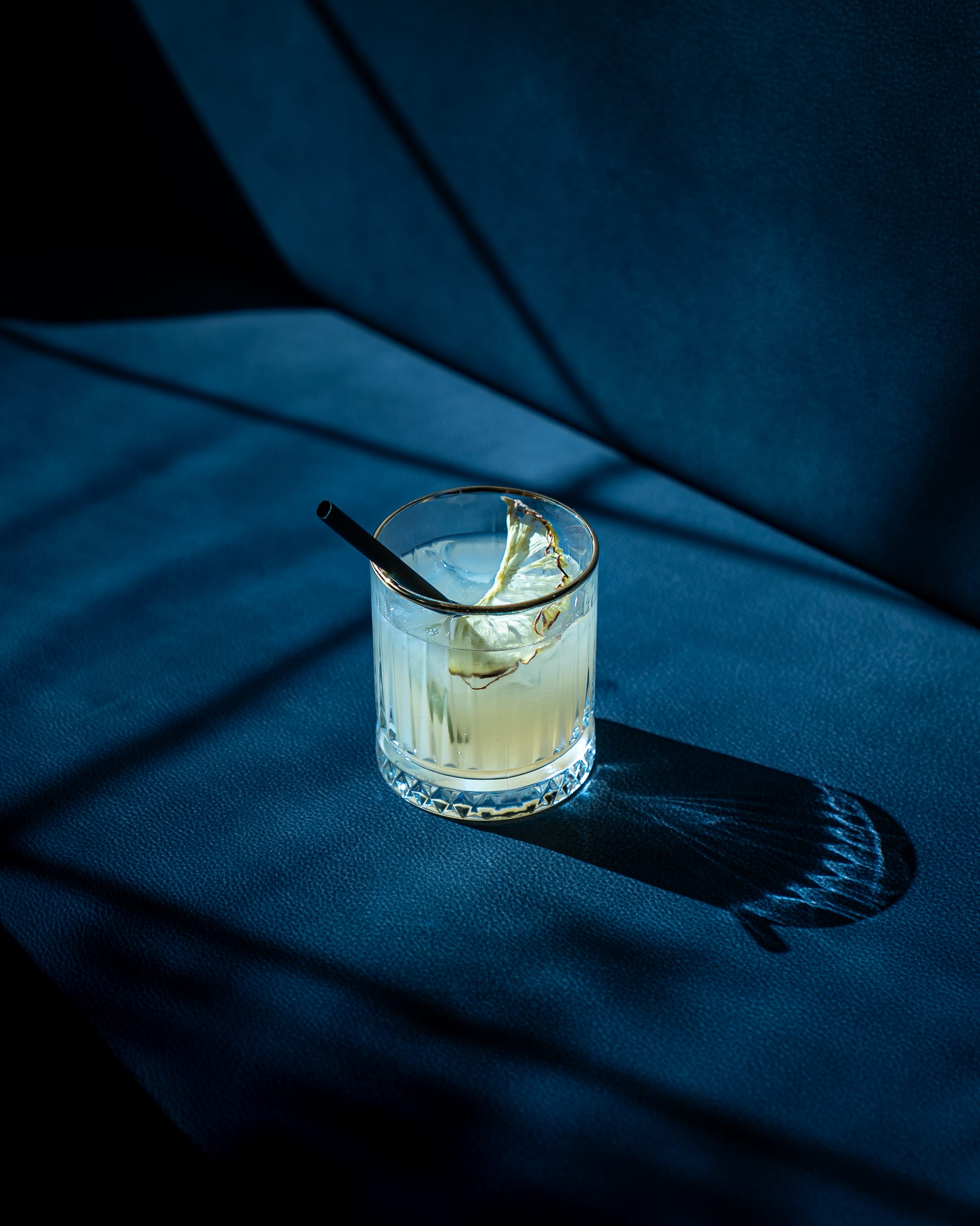 Cocktail on blue velvet in hard light