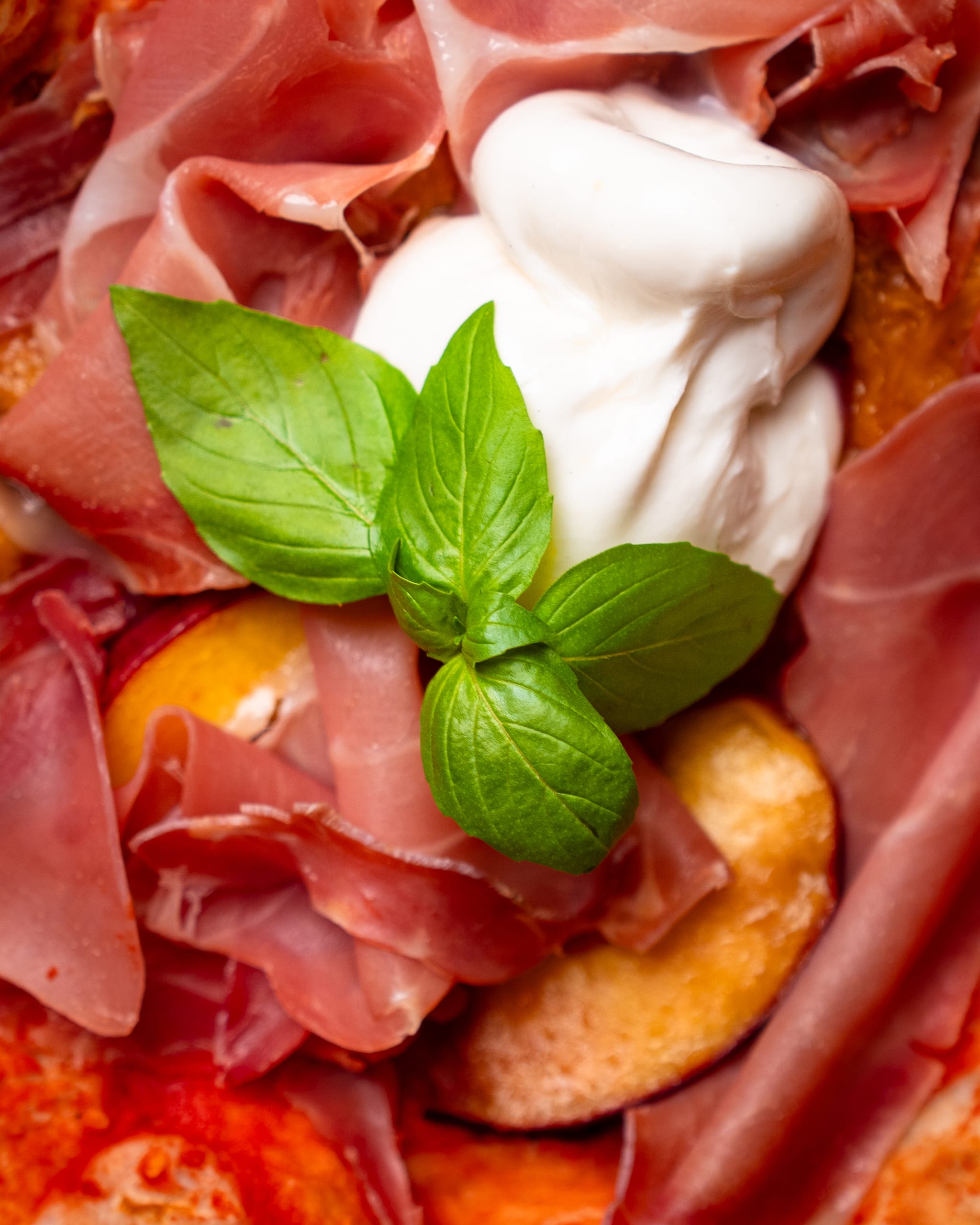 Prosciutto, burrata and basil, close-up