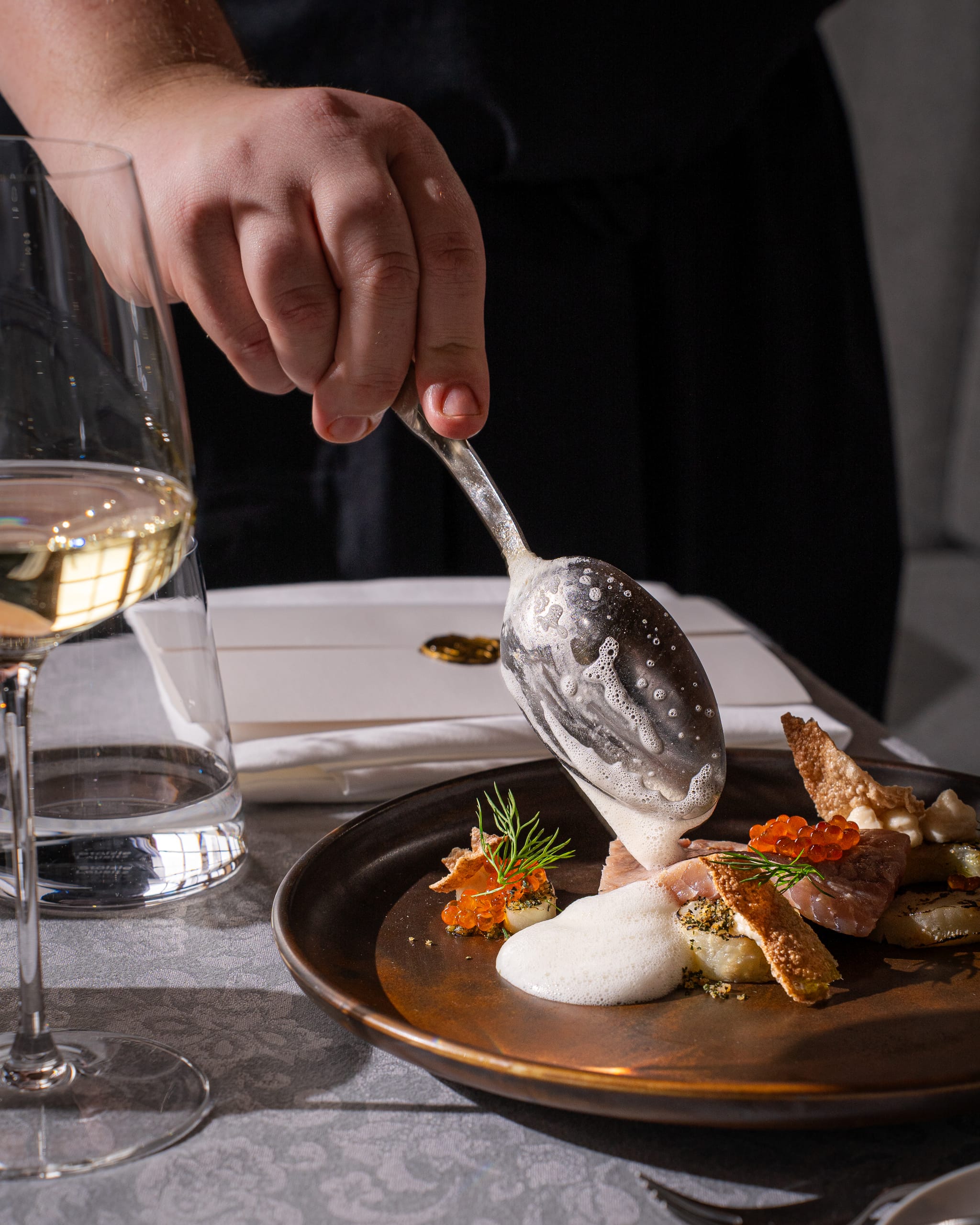 Sauce spooned over a plated fish dish